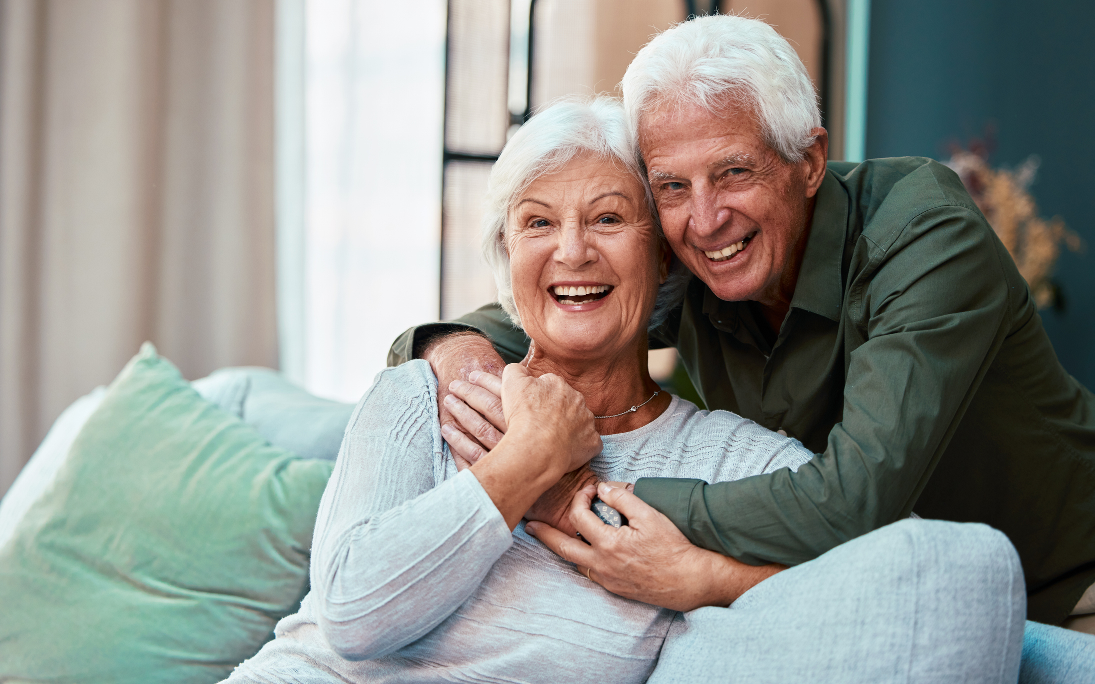 Happy senior couple smiling at their reverse mortgage in Canada